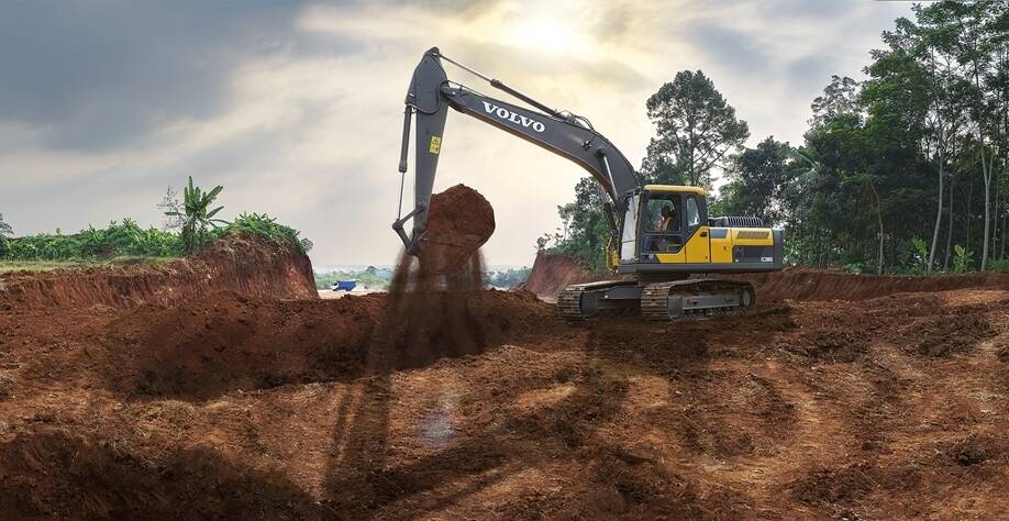Crawler excavator digging a deep earth pit on a construction site