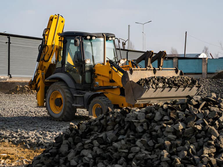 Backhoe loader loading stone on a construction site