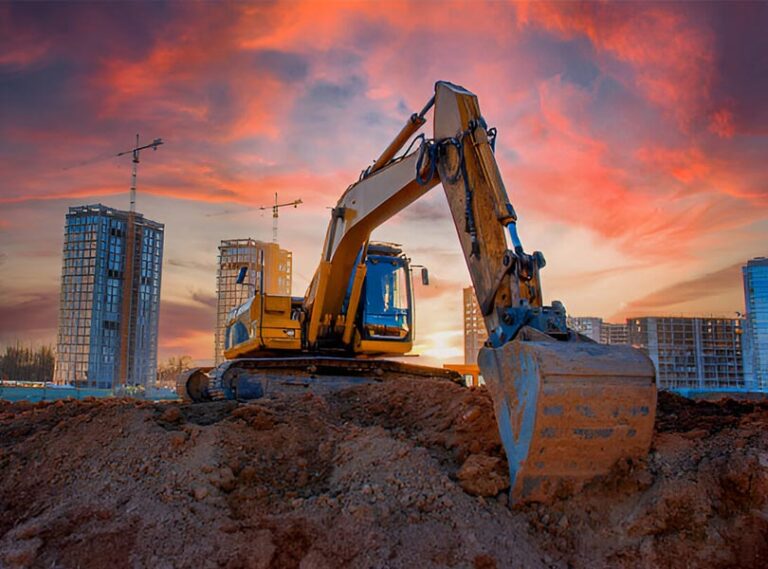 Excavator working on a heavy construction site at dusk