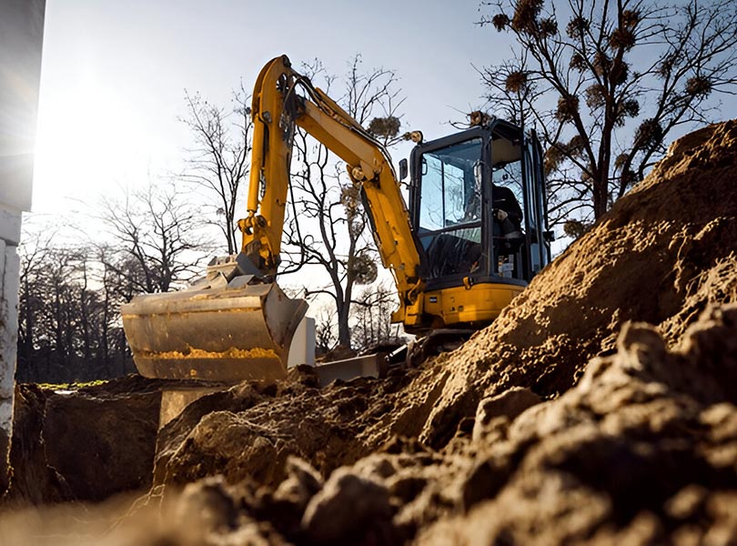Construction mini excavator digging trenches