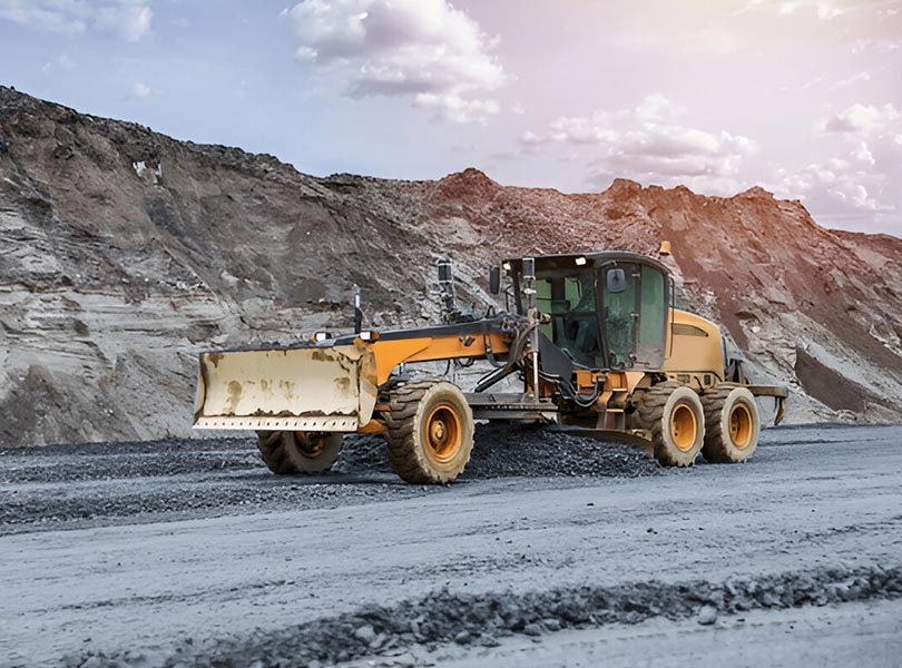 Motor grader grading mining road.