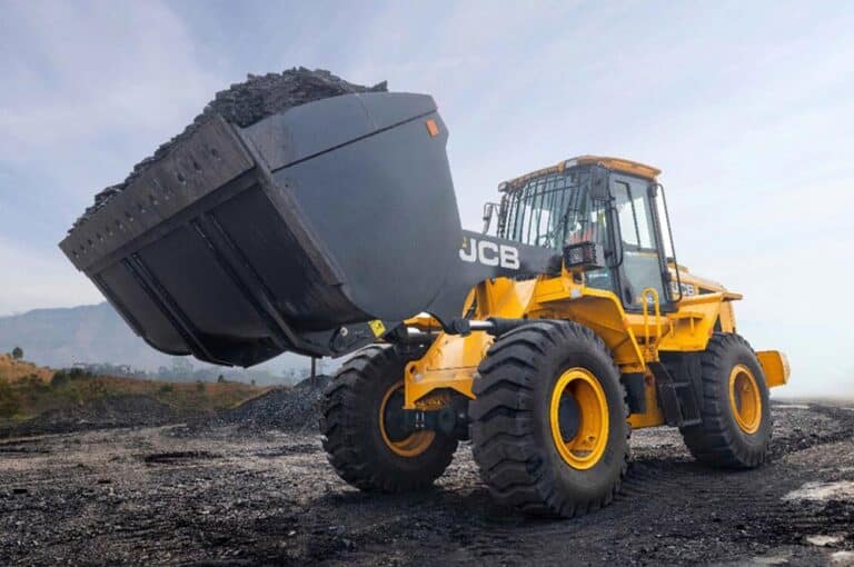 JCB wheel loader on large off-the-road tyres carrying coal at a stockyard