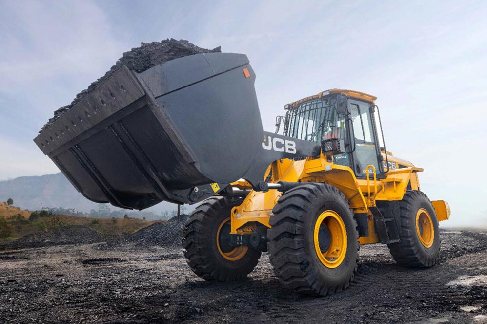JCB wheel loader on large off-the-road tyres carrying coal at a stockyard