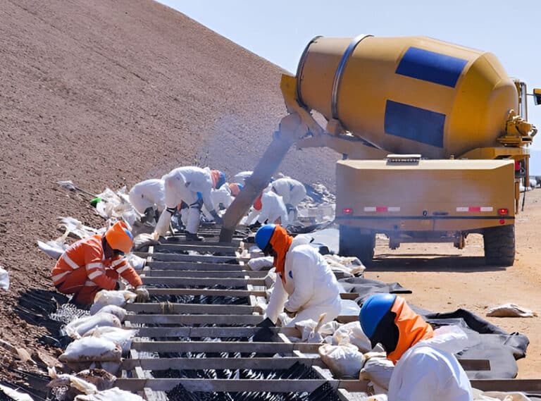Self-loading concrete mixer doing on-site volumetric batching at an Indian construction site